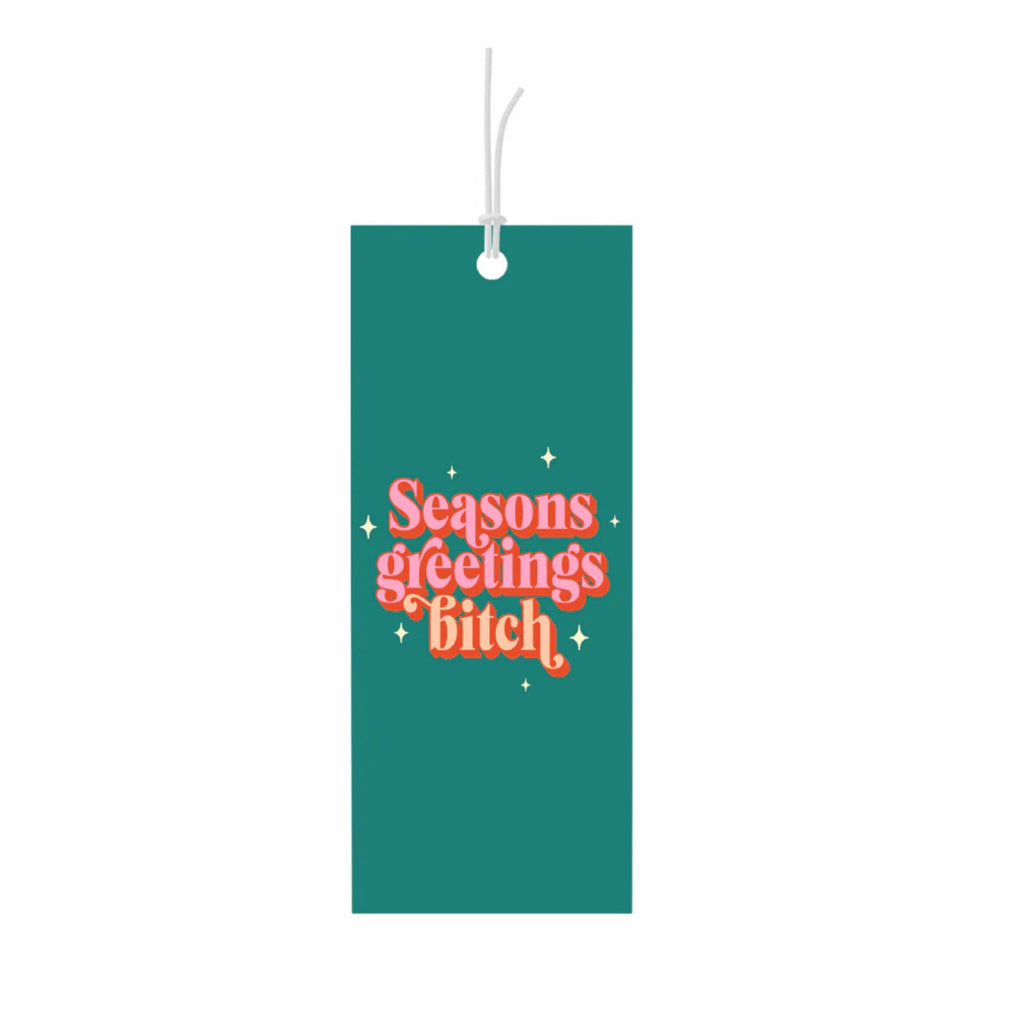 Green gift tag reading "seasons greetings bitch" in pink and orange text