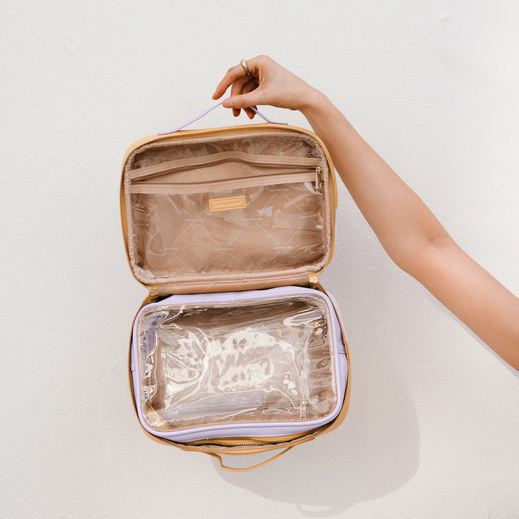 Person holding an open cosmetic case with a removable clear bag