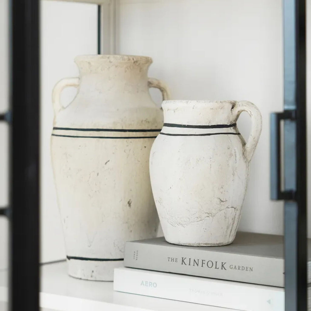 Lisbon Jug Small size sitting on two books inside a shelf. Next to a larger jug with the same black stripe design.