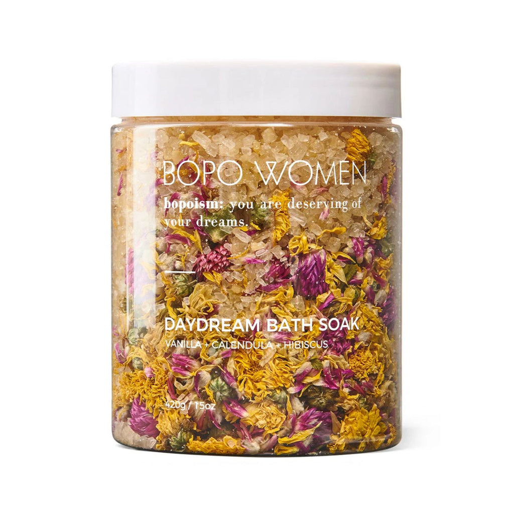 Bopo Women Bath Soak 420g in daydream.. A clear jar with white lid with yellow coloured bath salts sand dried flowers