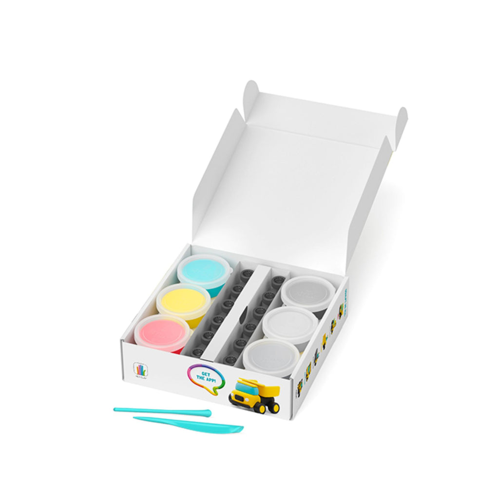 Open white box with 6 pots of clay in various colours and an assortment of toy wheels inside, with two clay tools