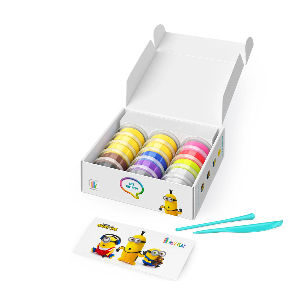 An open white box with 15 tubs of clay in various colours and two clay tools with a card with minions on it