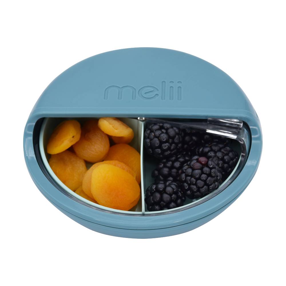 Round blue spinning lunch container filled with fruits