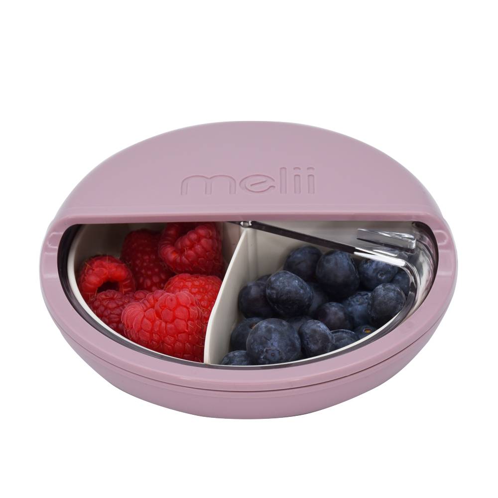 Round pink spinning lunch container filled with fruits