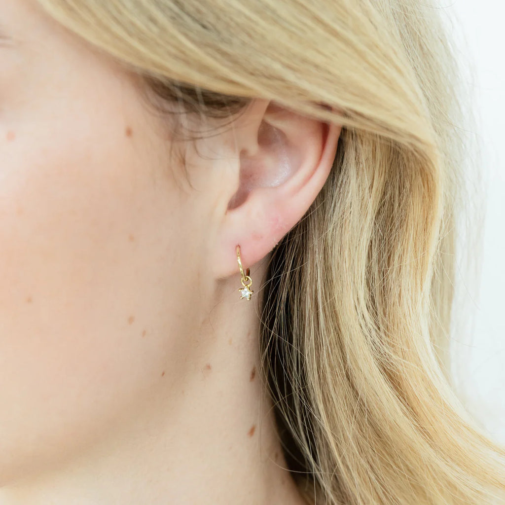 Girl wearing Gold hoop earrings with star shaped Zircon