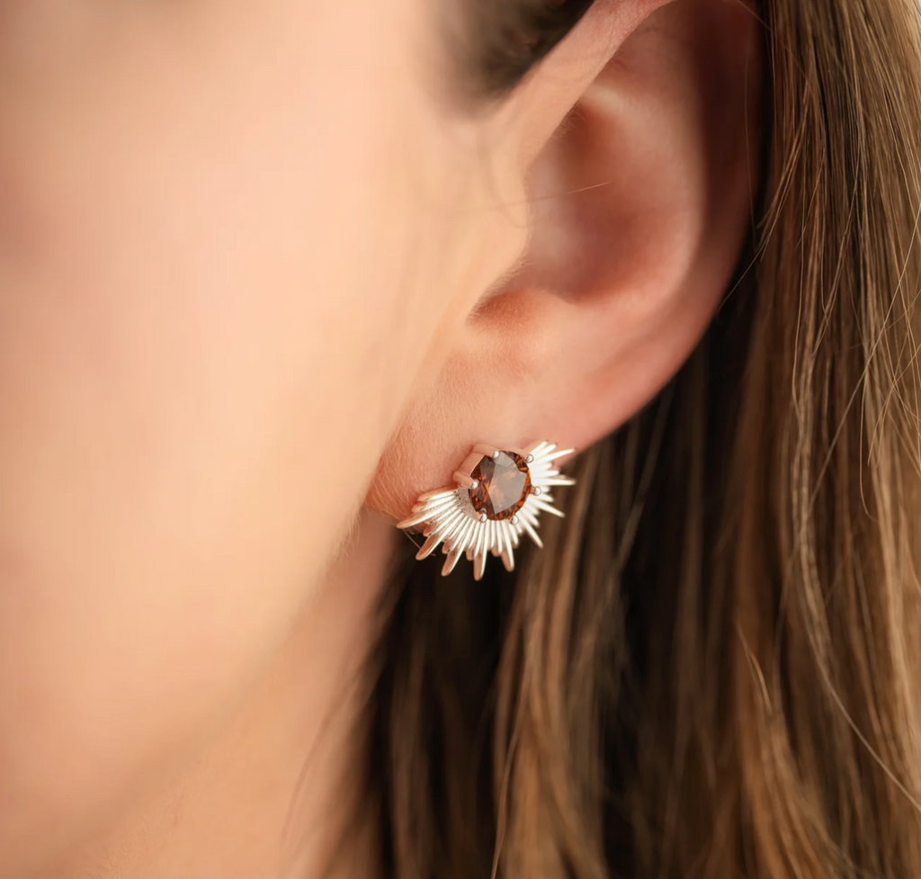 Woman wearing silver earrings with brown stone