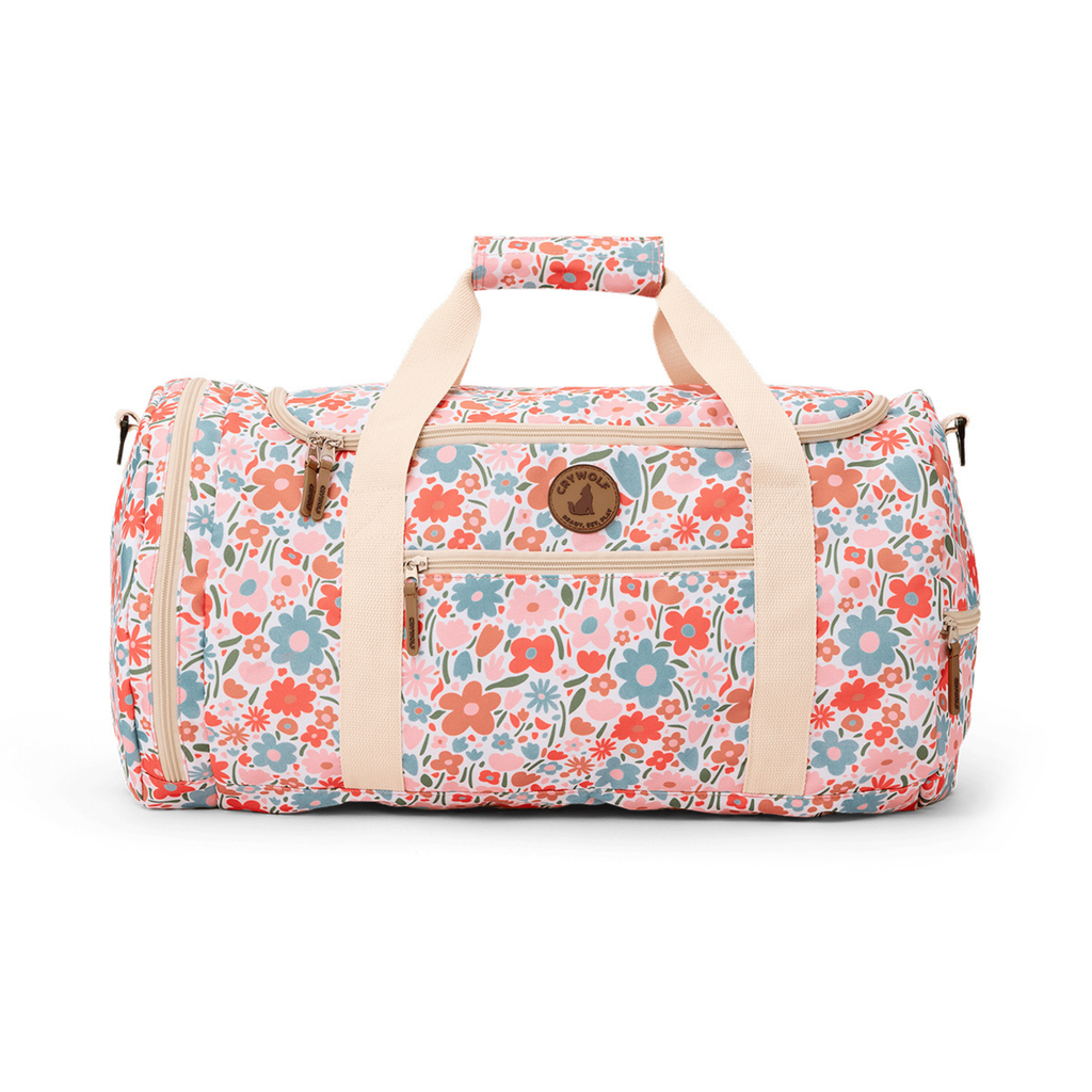 A pink and white floral design duffle bag suitable for use as a luggage displayed indoors.