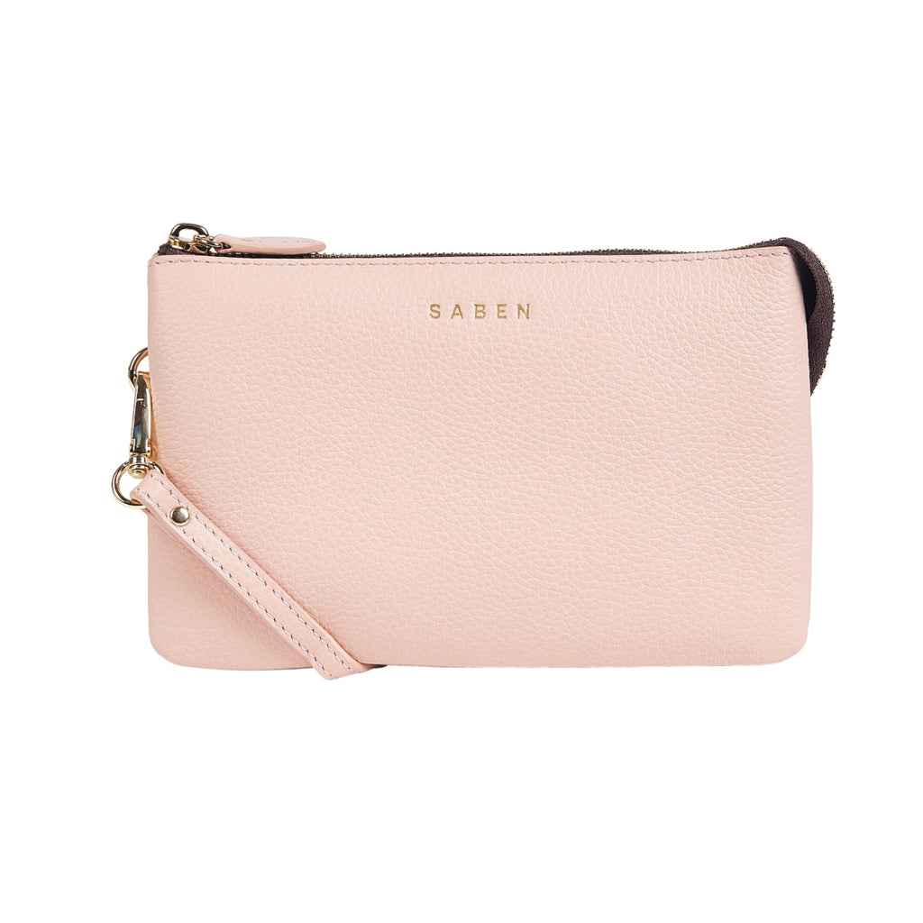 A white background with a blush pink rectangle leather bag with a top gold zip opening, gold hardware and gold embossed SABEN branding on the front. 