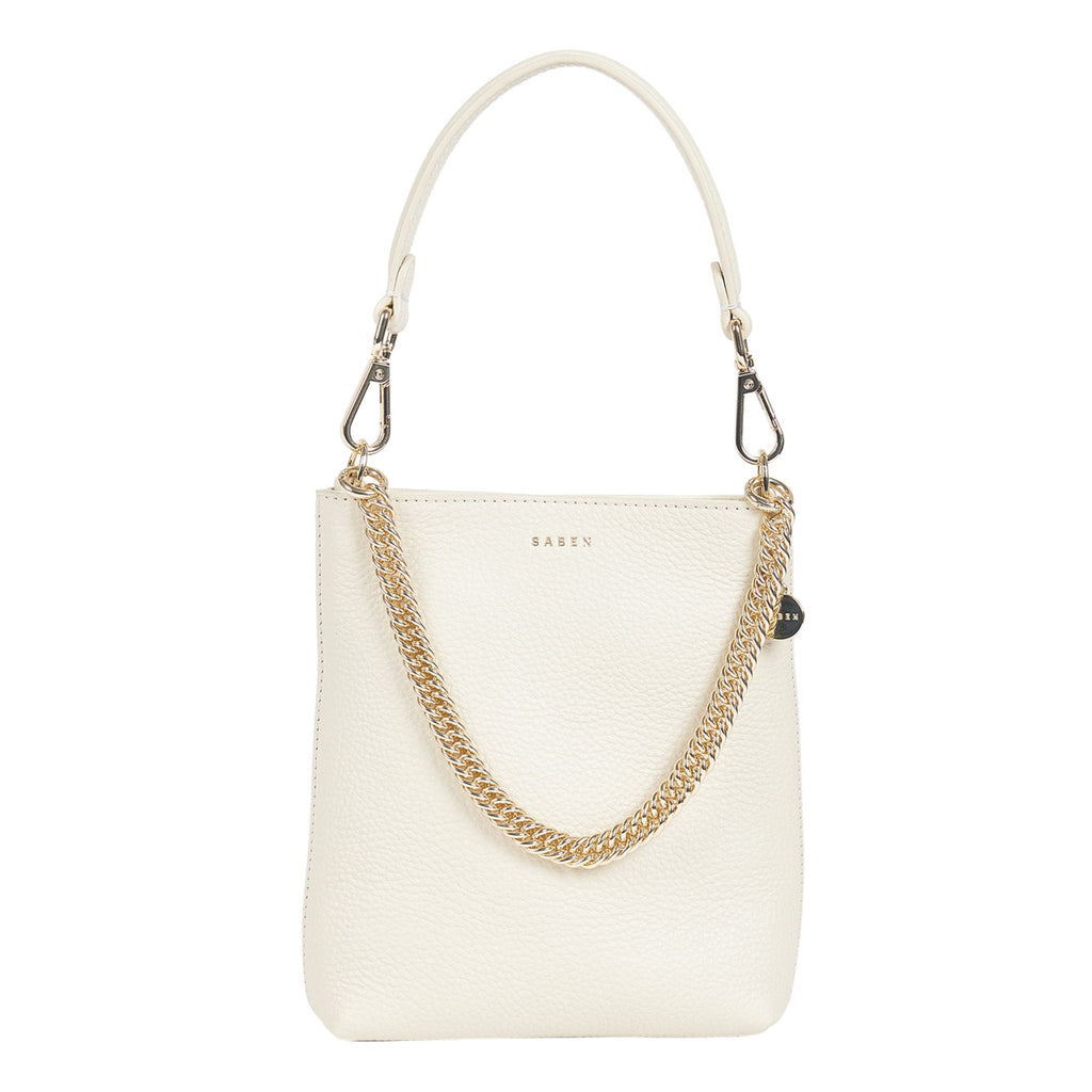 A white background with a sandcoloured rectangle leather bag featuring a hand strap, gold chain detail across the front and embossed SABEN branding on the front. 