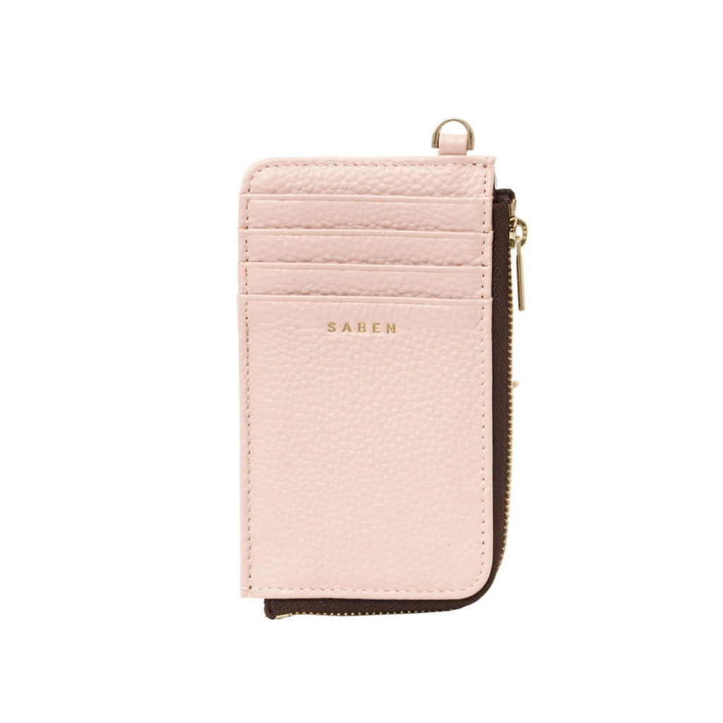 A white background with a blush pink rectangle leather card holder  with D ring attached to the top, 4 card compartments and zip opening on the side.  Embossed SABEN branding on the front