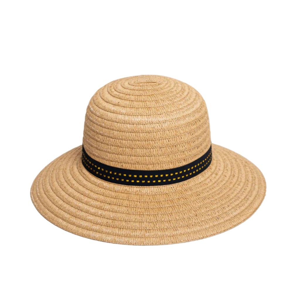 A white background with a natural coloured woven, wide brim hat with black and gold ribbon around the centre.