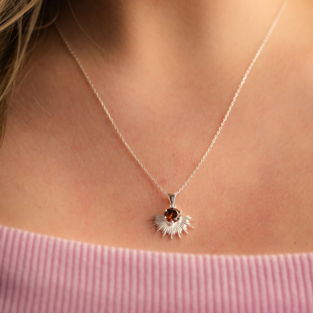 Women wearing silver necklace with brown stone