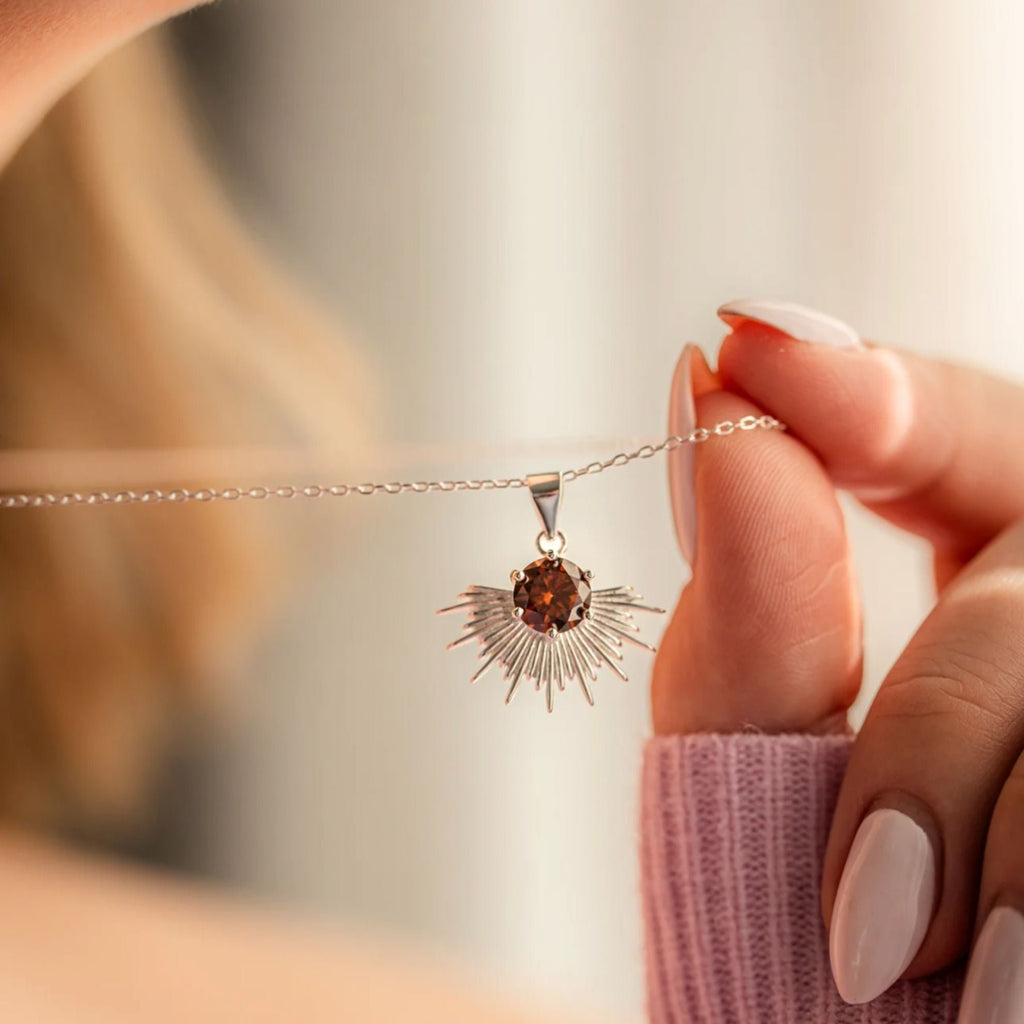 Women holding silver necklace with brown stone