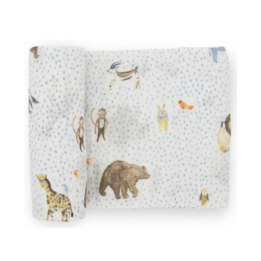 Muslin baby swaddle with illustrated animals and blue spots. Against a white background