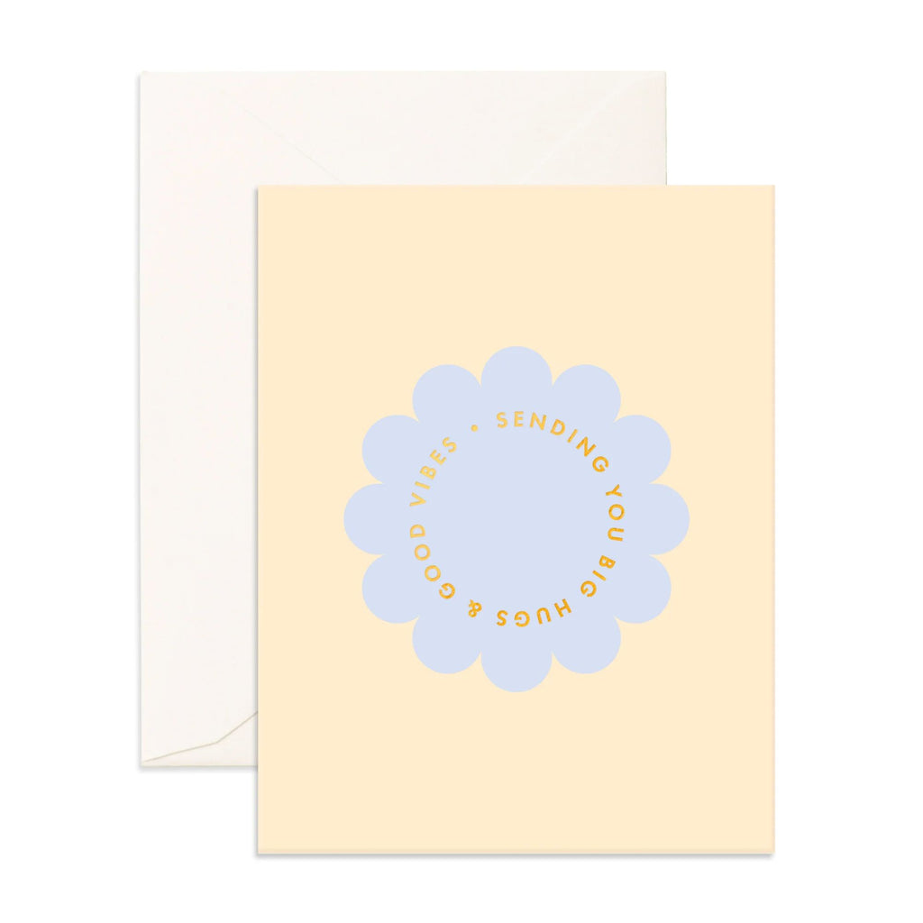 Light yellow greeting card with a light blue flower reading "sending you big hugs & good vibes" with a envelope