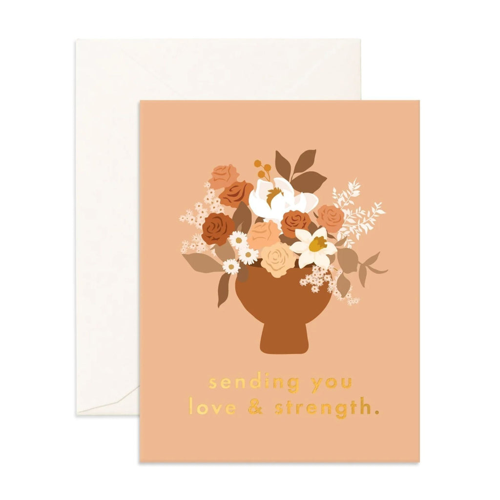 Light orange greeting card with a floral arrangement on it reading "sending you love & strength" with an envelope