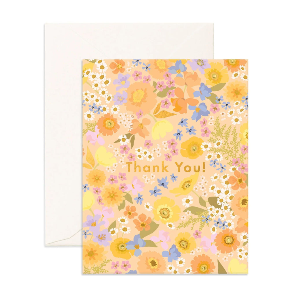 Light pink greeting card with multicoloured flowers on it reading "Thank you!" in gold text with an envelope