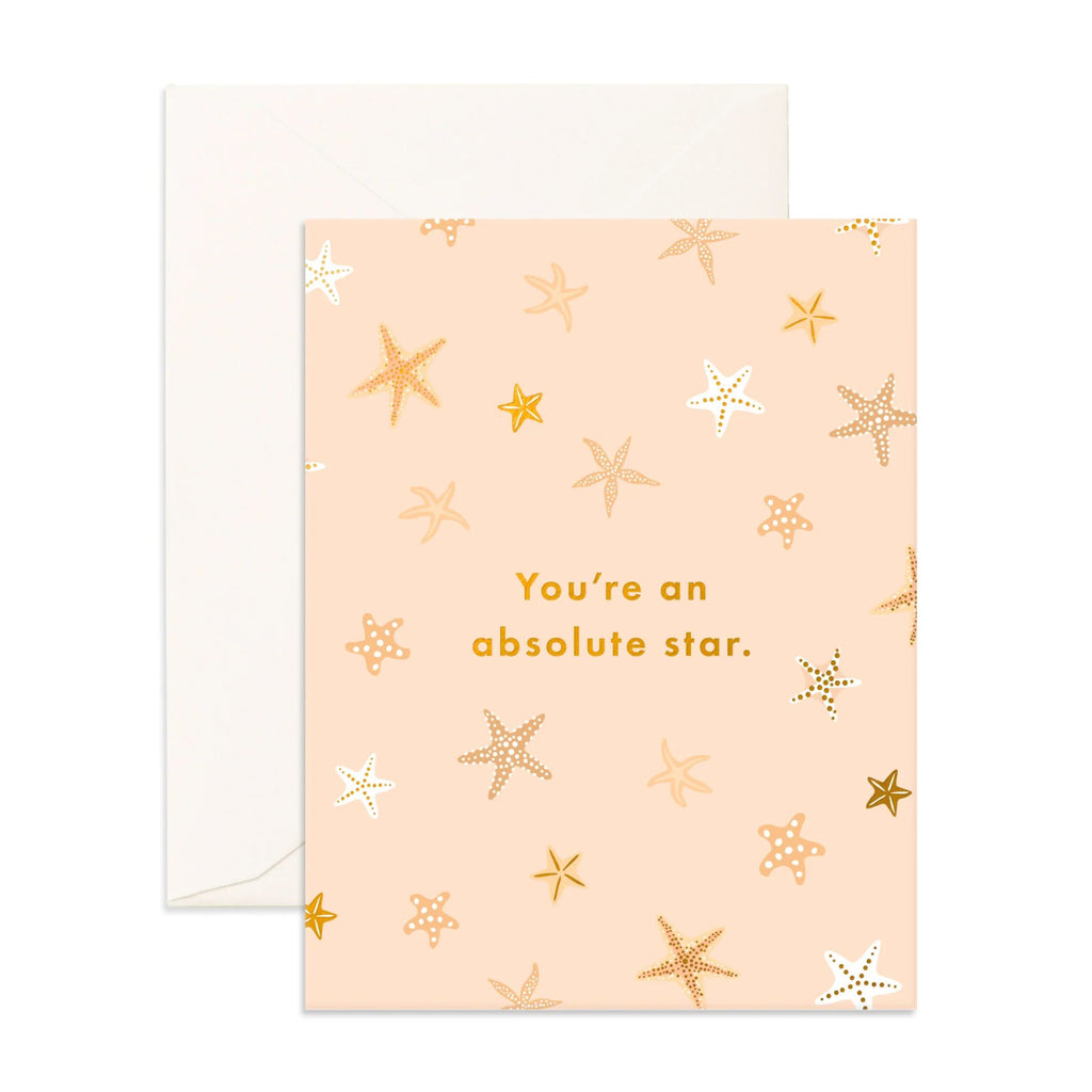 Light pink greeting card with starfish on it reading "You're an absolute star " in gold text with an envelope