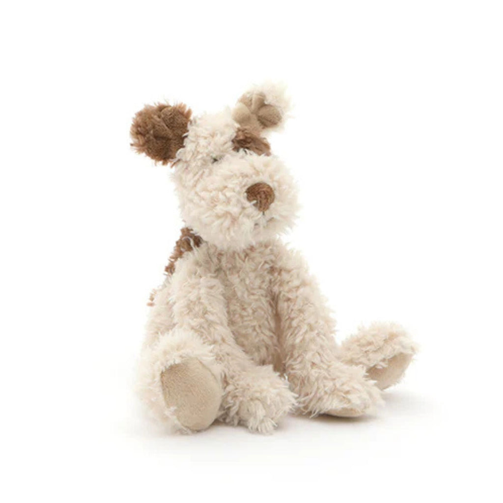 Soft toy puppy dog in beige with a brown ear and nose. Set against a white background