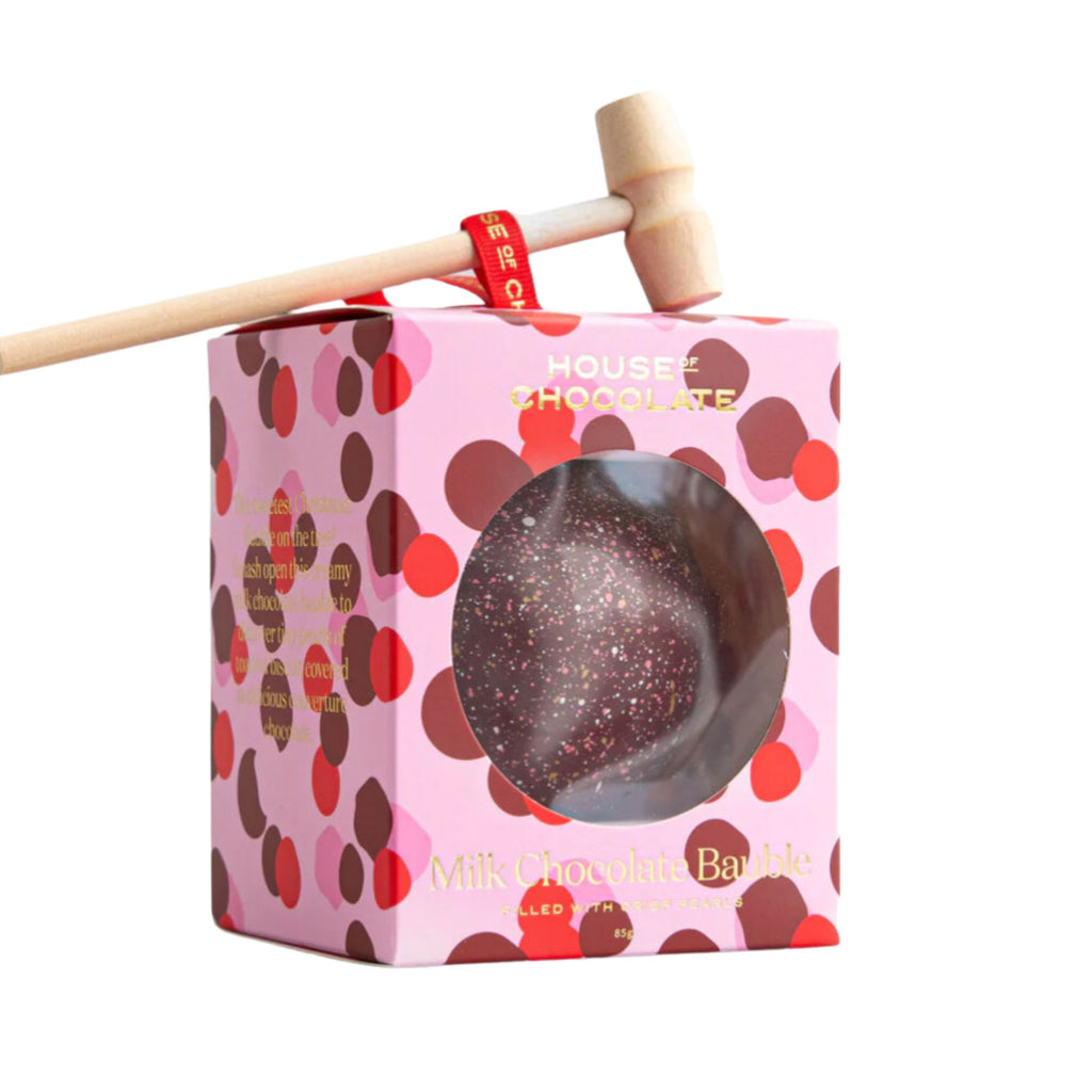 Pink and red box filled with a chocolate ball and a wooden hammer