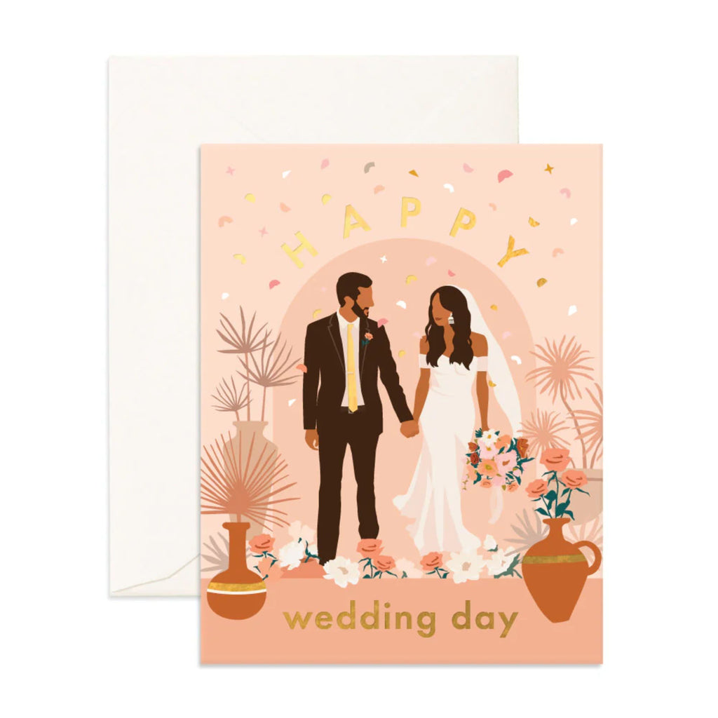 Light pink greeting card with a married man and woman and flowers and foliage on it reading "wedding day" in gold text with an envelope