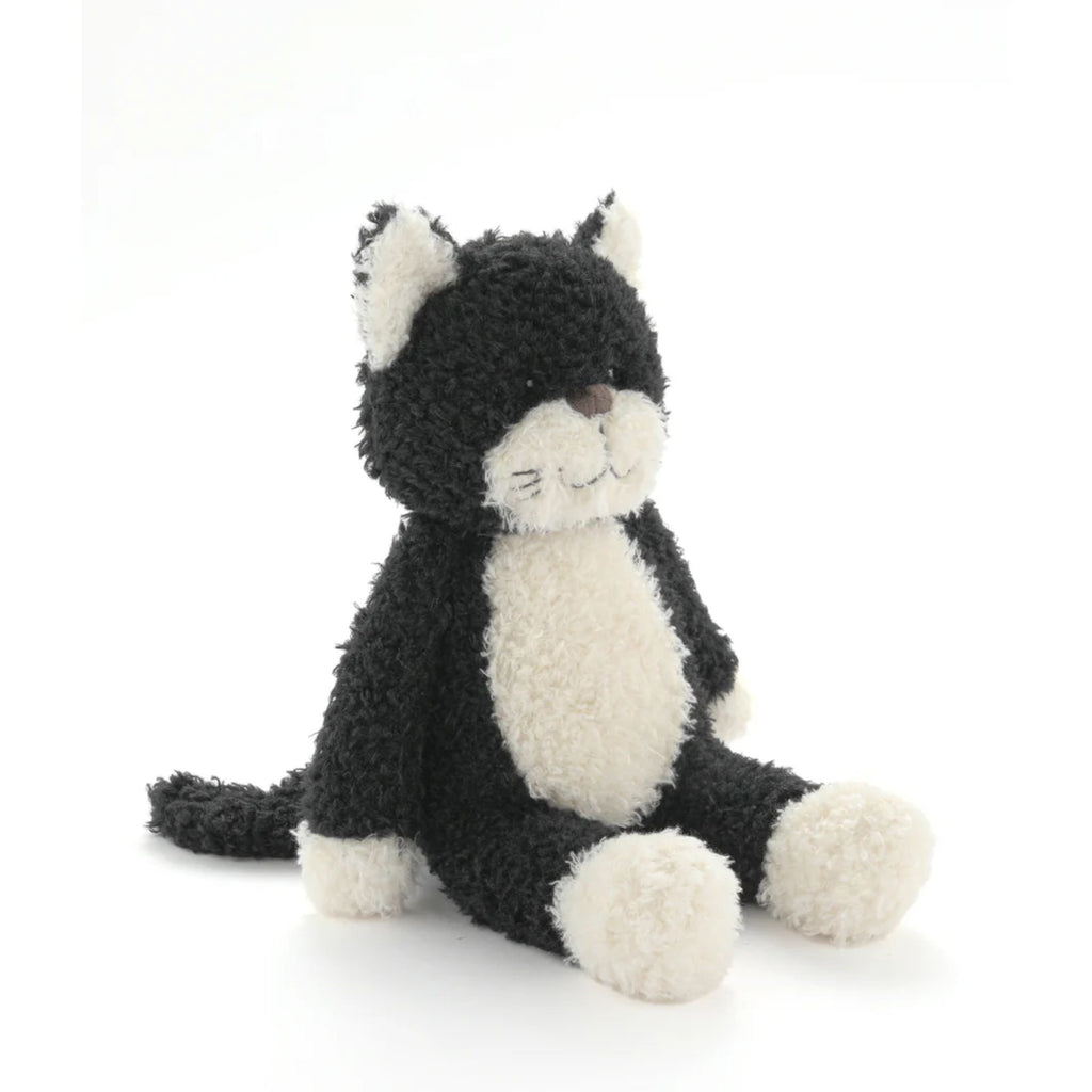 A stuffed toy black and white cat sitting against a white background