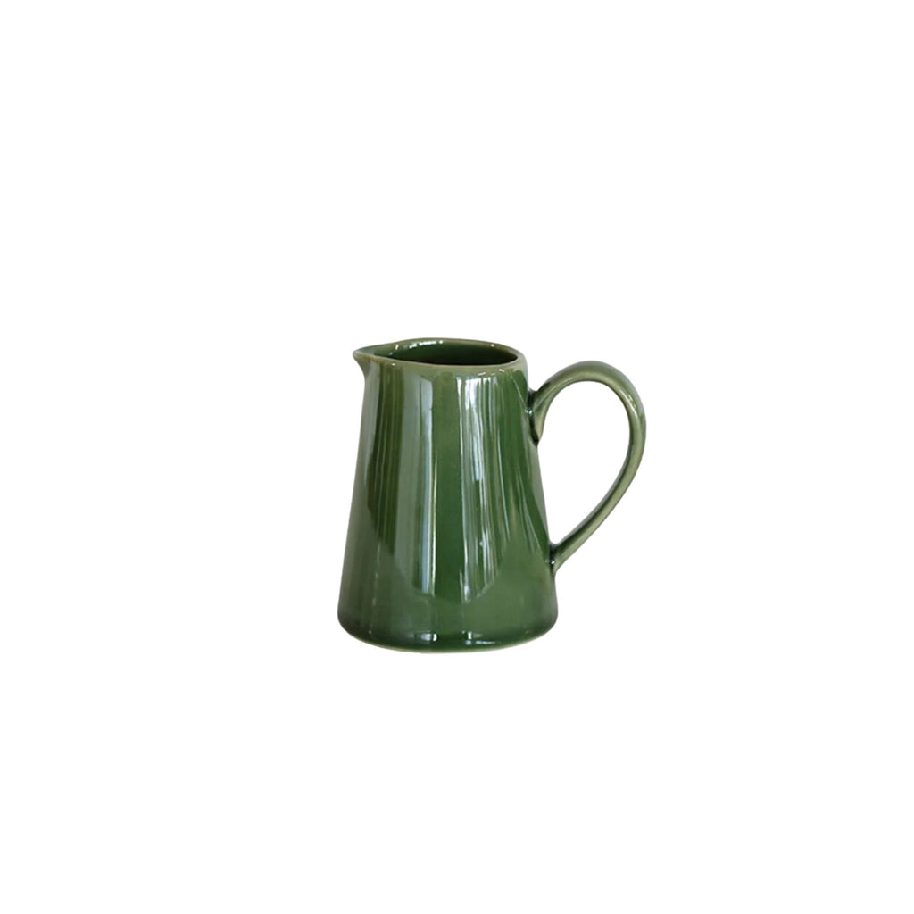 A small green ceramic cream pitcher