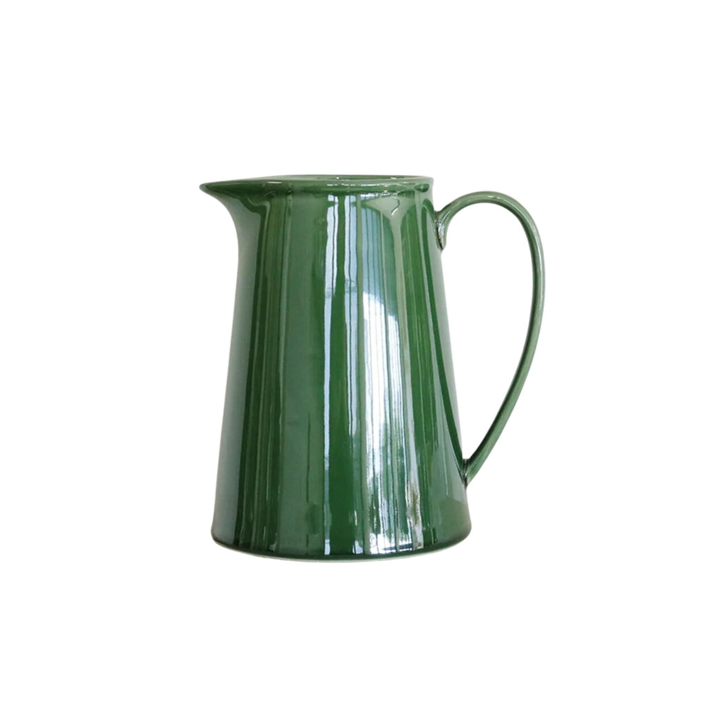 A large green ceramic  jug against a white background.