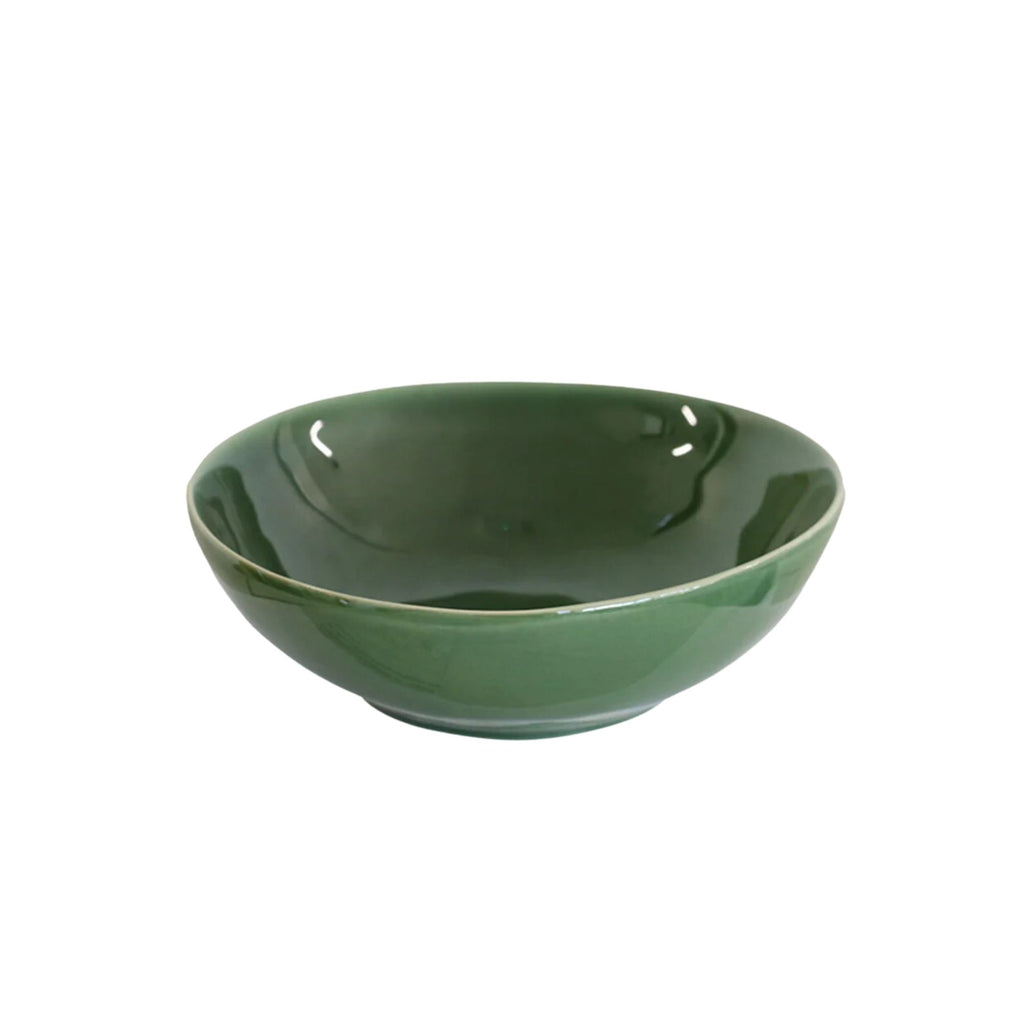 A green ceramic eating bowl against a white background.