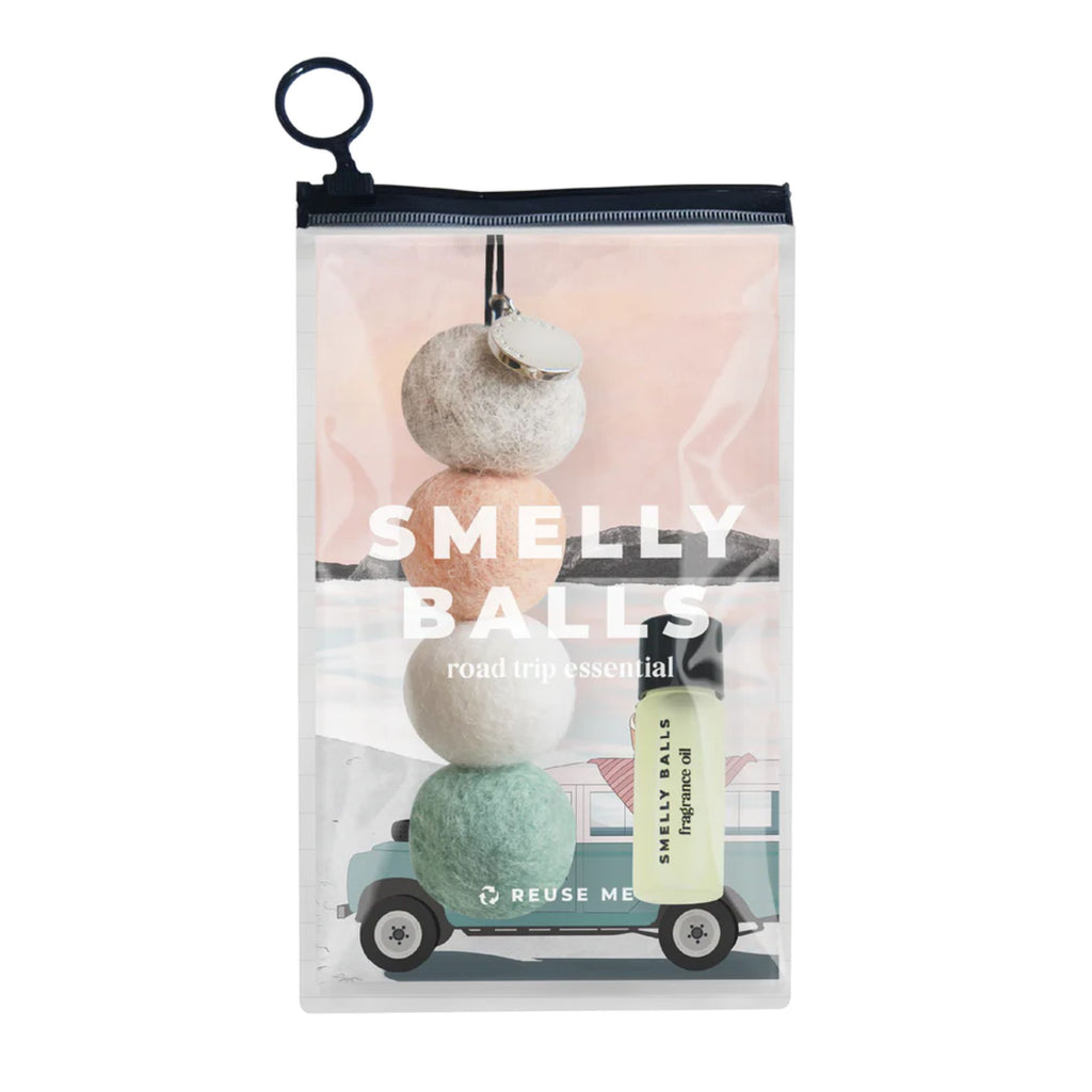 A clear pouch with a car air freshener composed of four felt balls in grey, pink, white and blue on a string with a silver charm and a bottle of fragrance oil with a car illustration card behind them