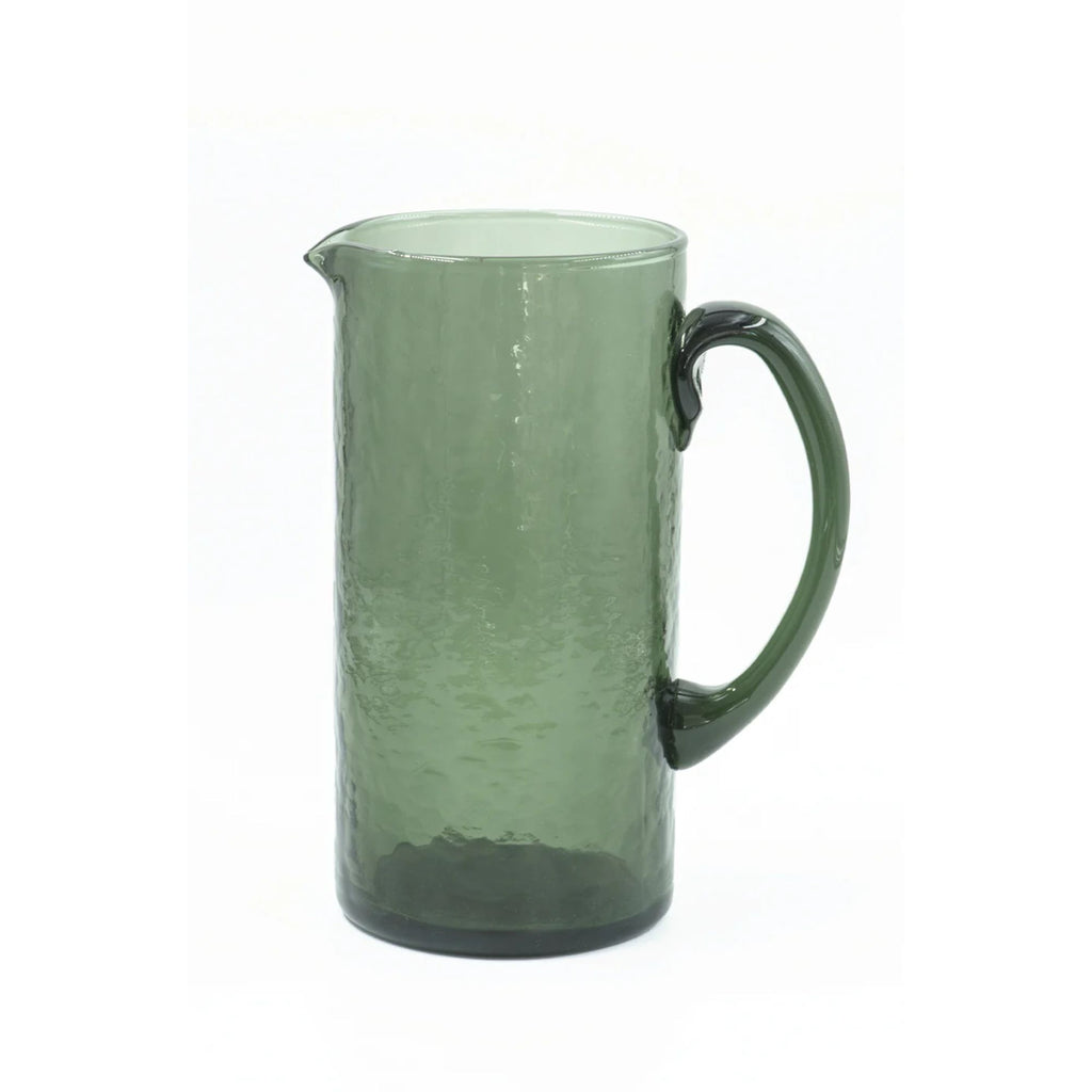 A hammered texture green glass jug on a white background