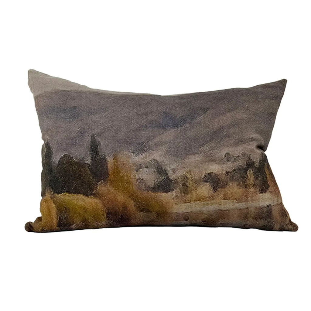 A throw pillow with a dark painted landscape on it