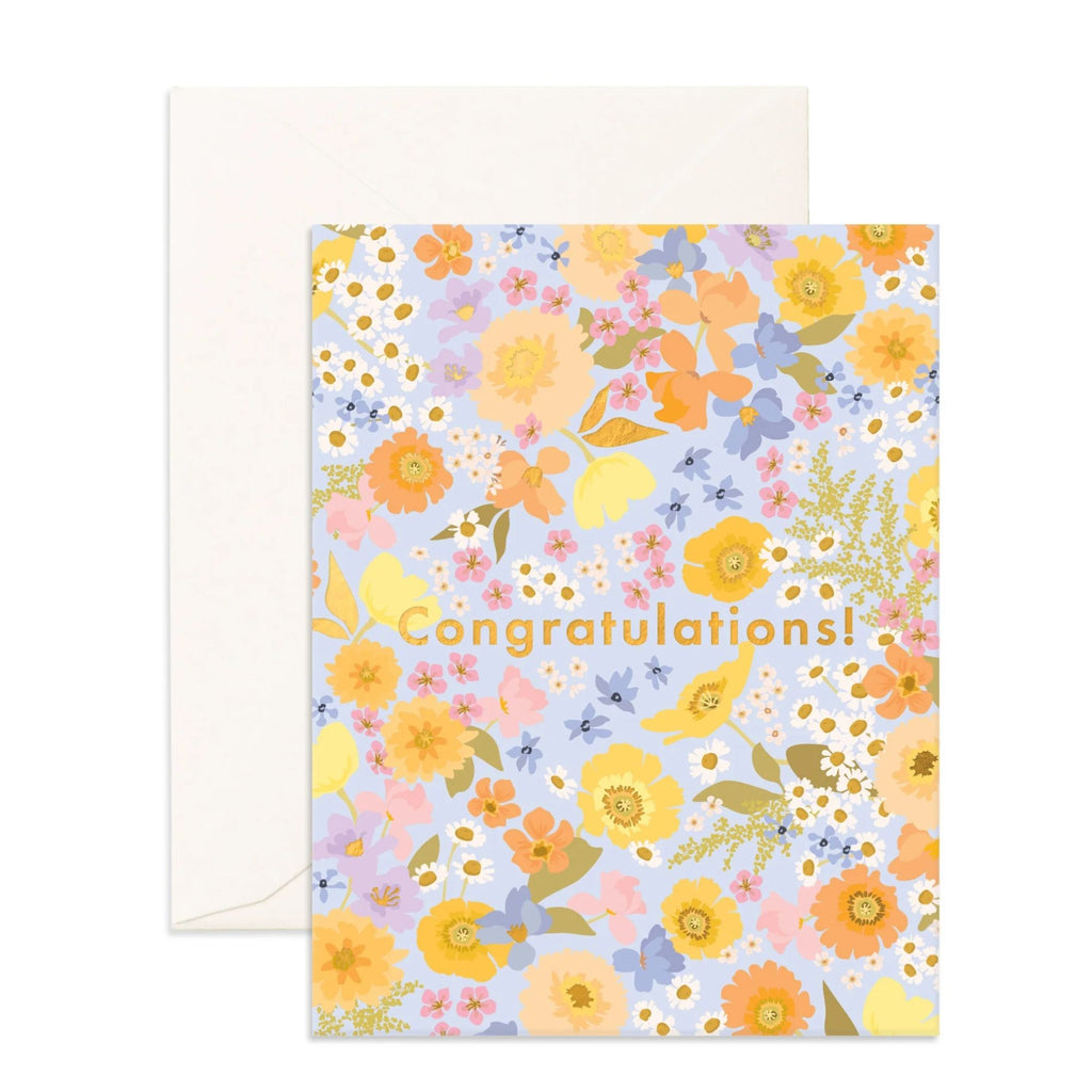 Light blue greeting card with multicoloured flowers and foliage on it reading "congratulations" in gold text with an envelope