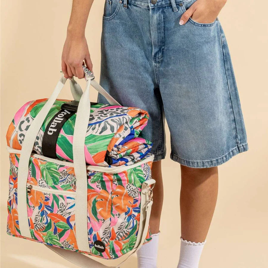 Lower half of girl holding colourful cooler bag and matching wrapped up picnic blanket