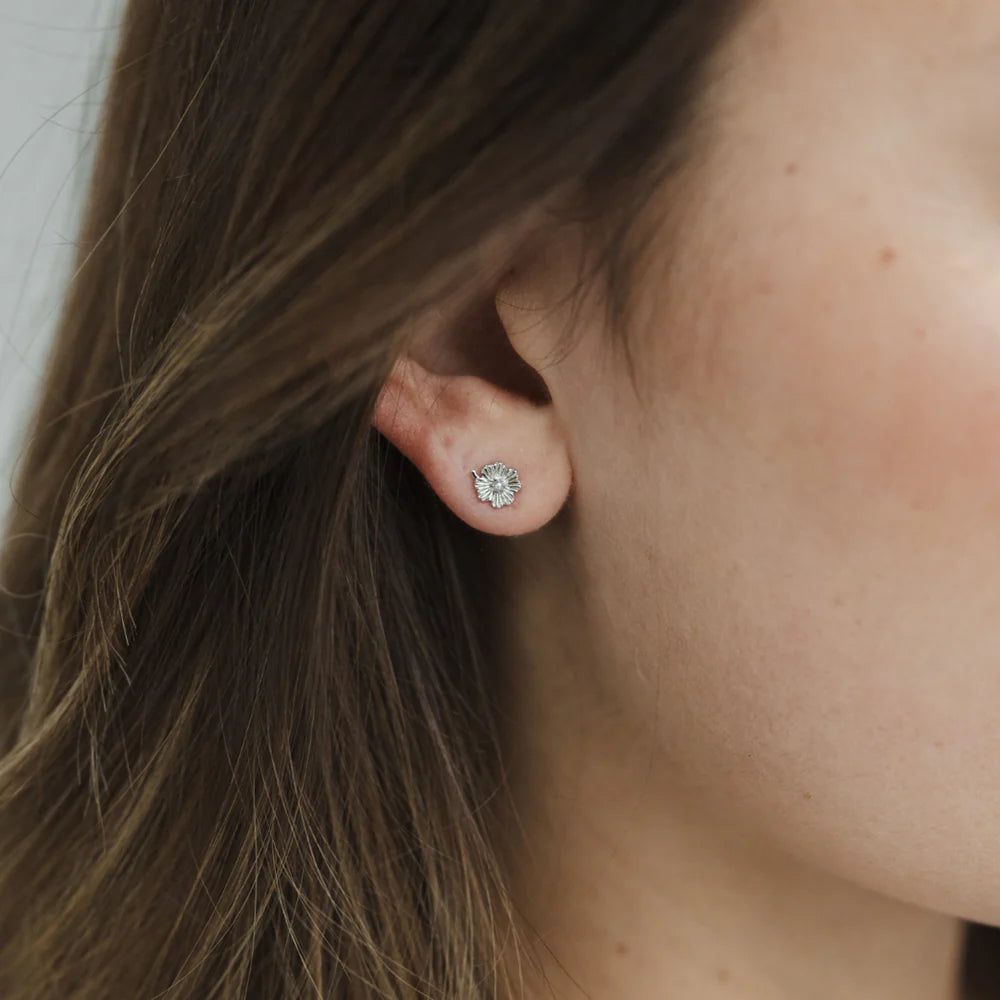 Girl wearing Silver flower studs with a pearl centre