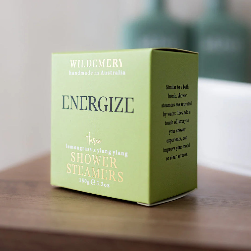 Angled light green shower steamer box in energize scent on a shelf