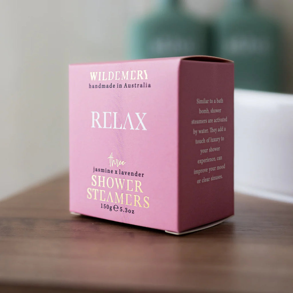 Angled light pink shower steamer box in relax scent on a shelf